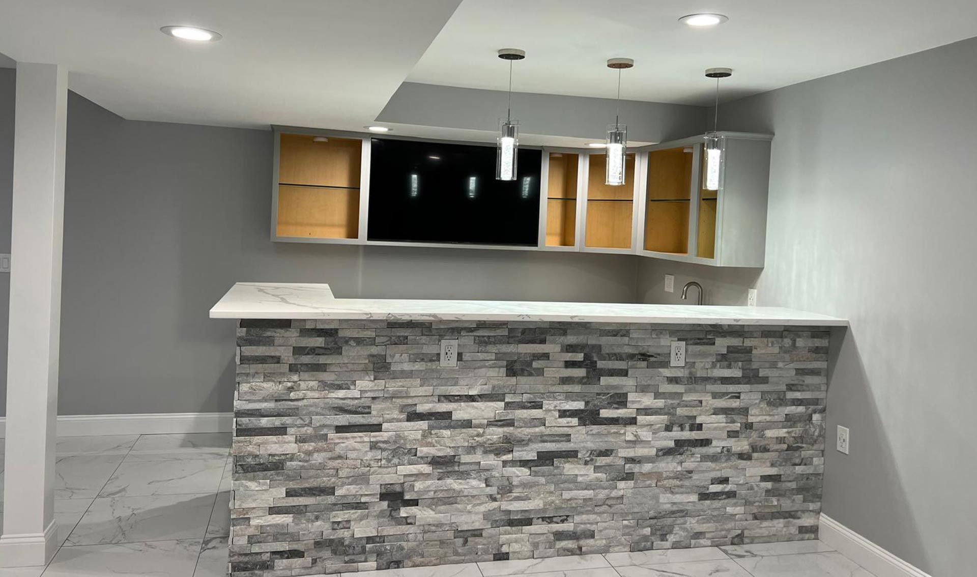 A basement with a stone wall and a bar.