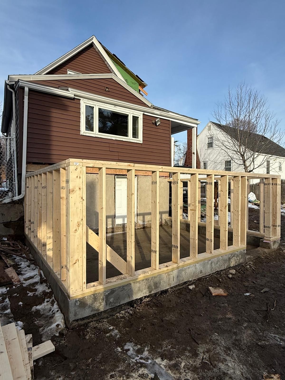 A house is being remodeled with a wooden deck.