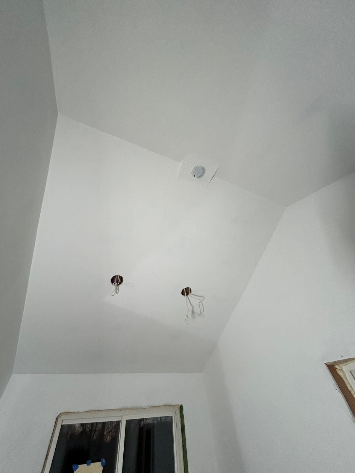 A room with a white ceiling and a window.