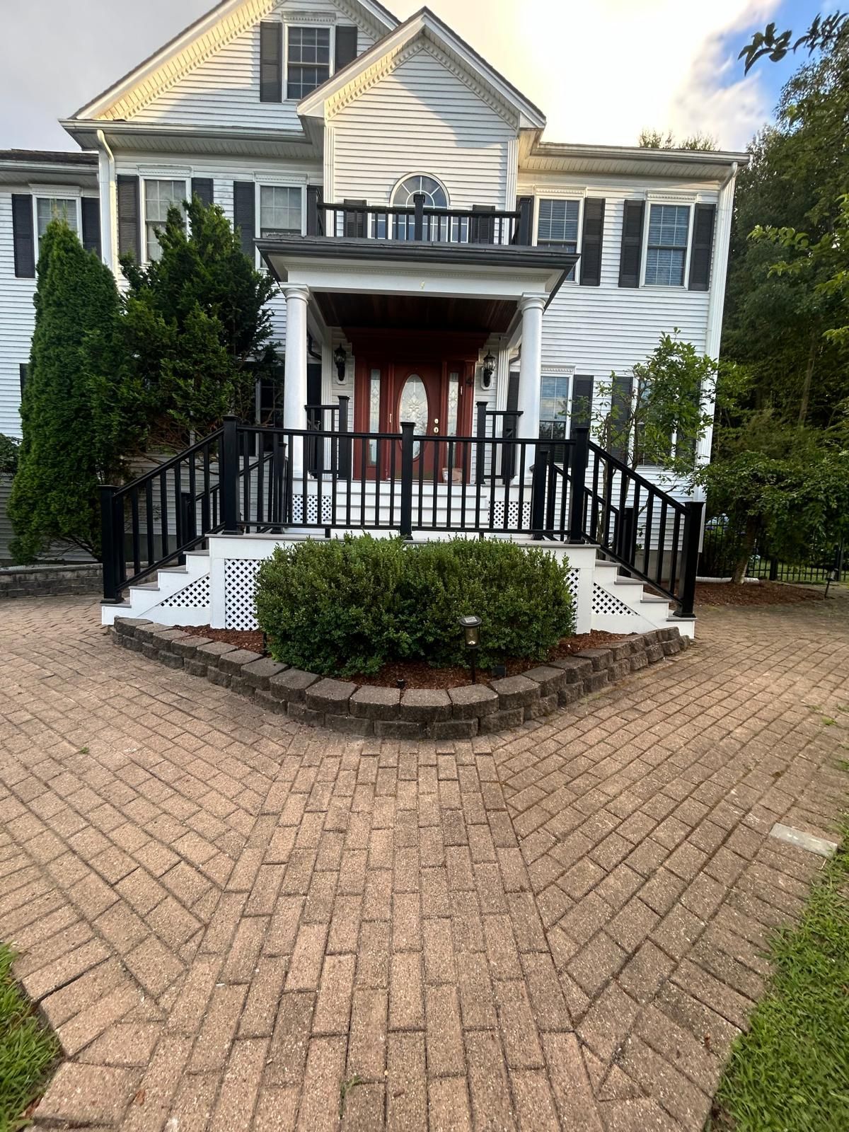 A large white house with a brick walkway leading to it.