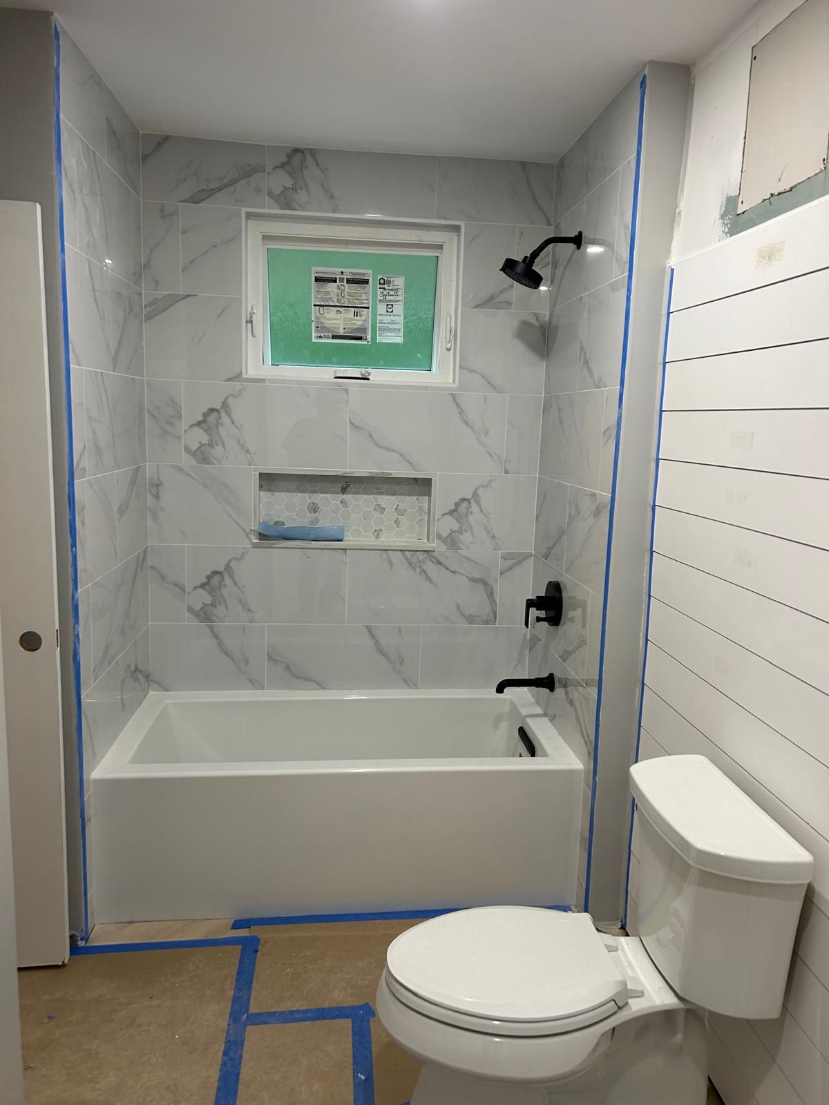 A bathroom with a toilet , bathtub and shower.