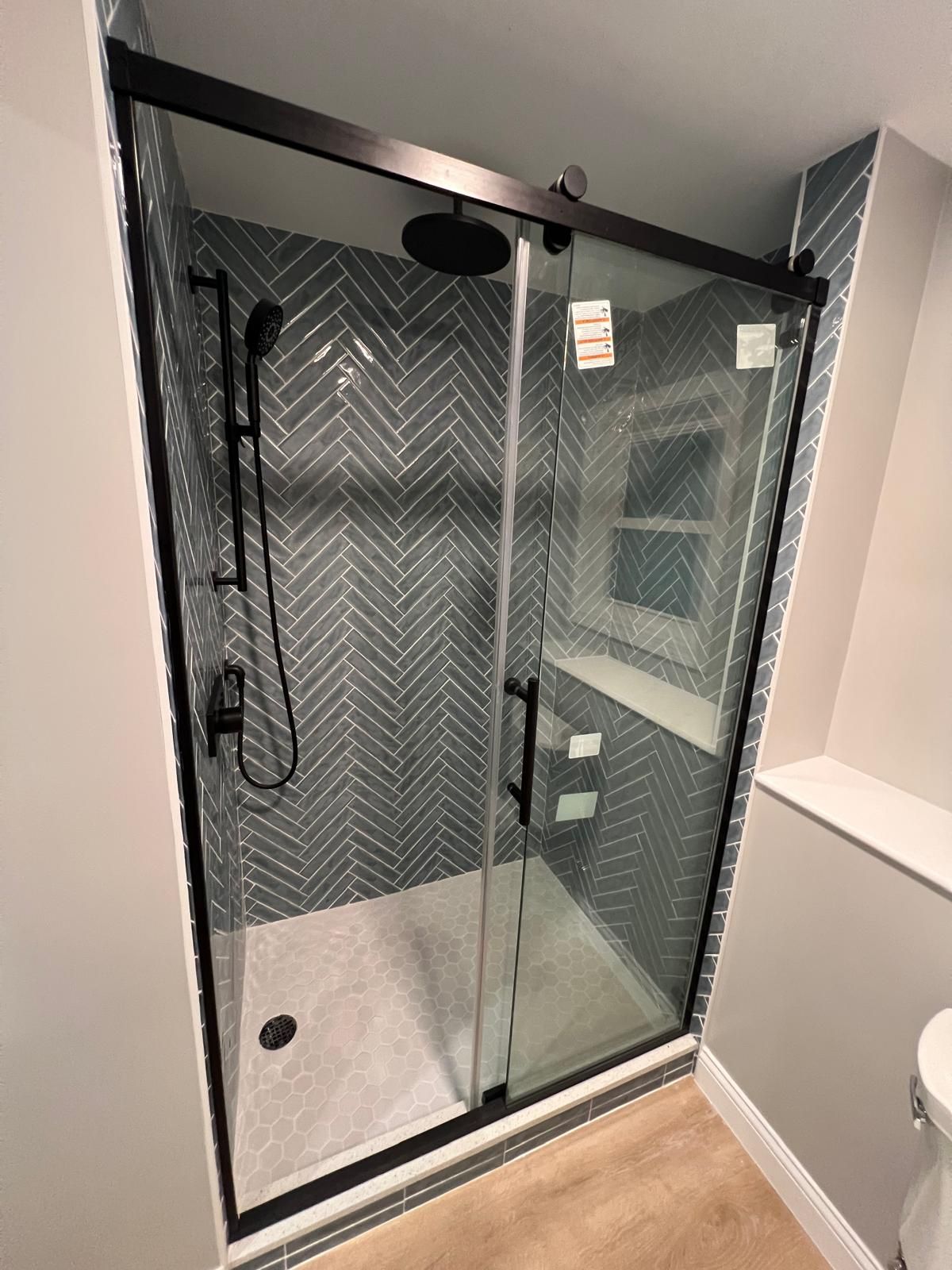 A bathroom with a sliding glass shower door and a shower head.