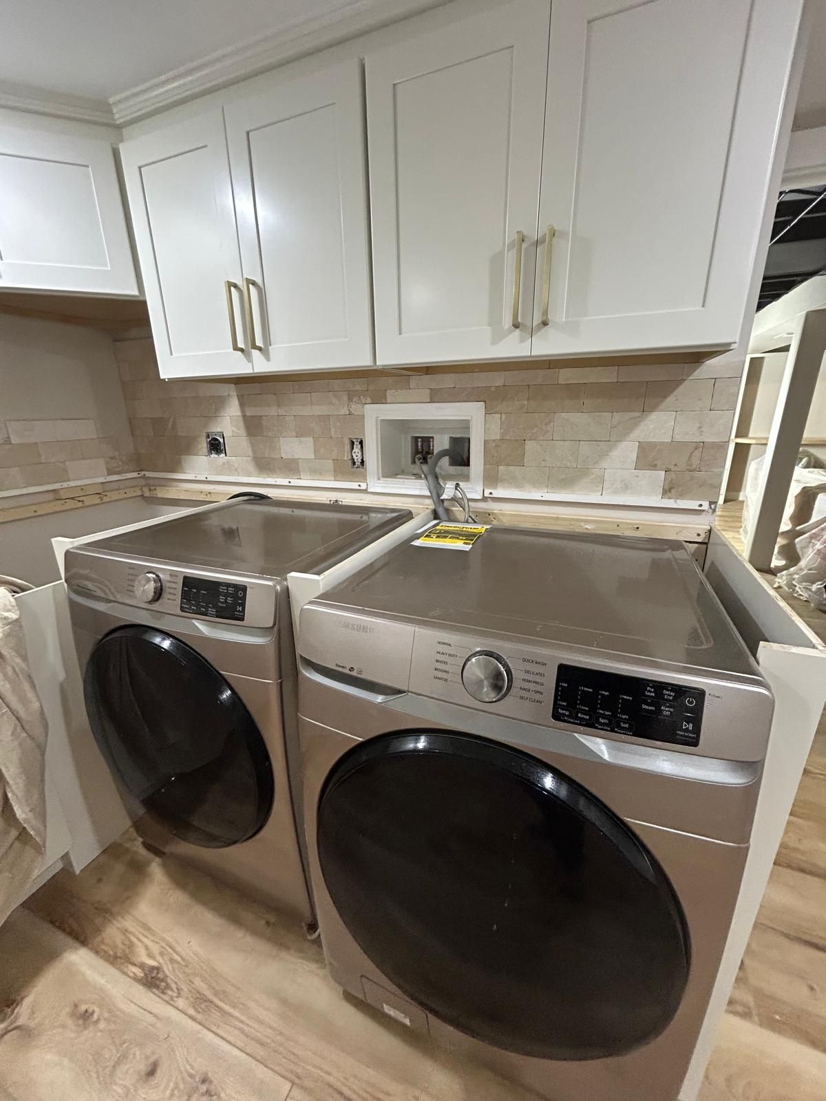 A laundry room with a washer and dryer in it.