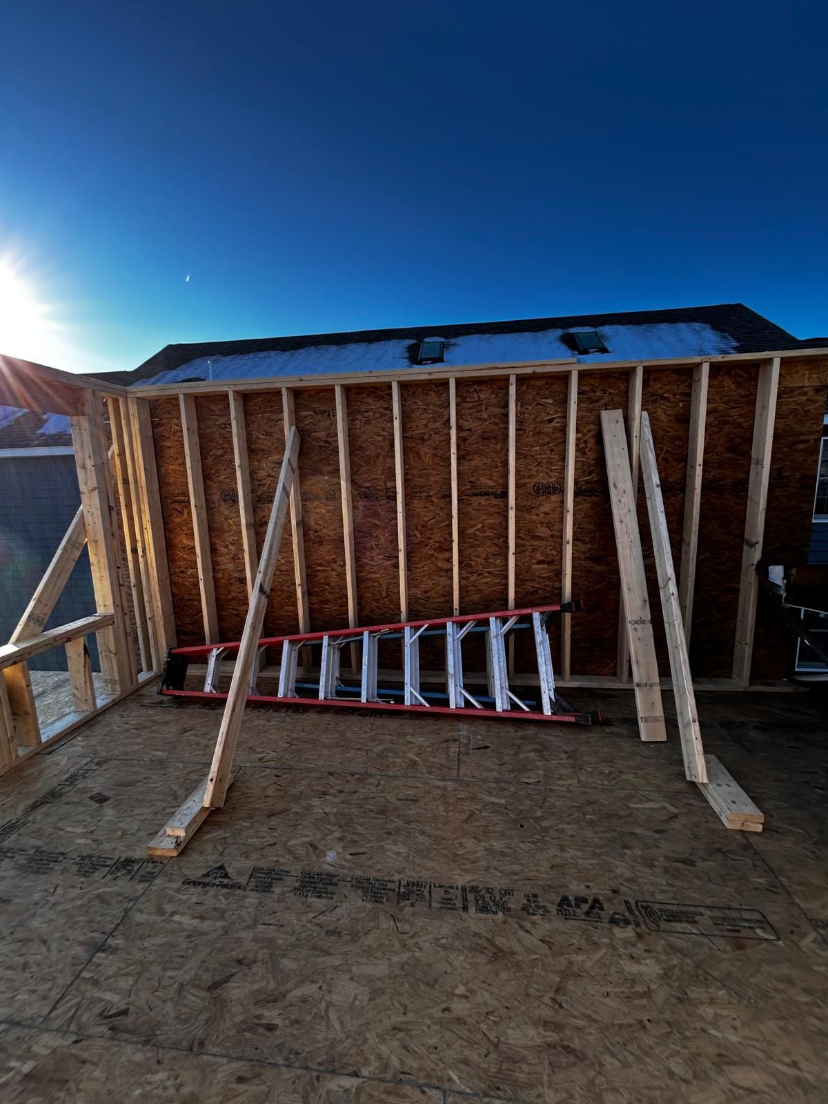 A ladder is sitting on top of a wooden structure under construction.