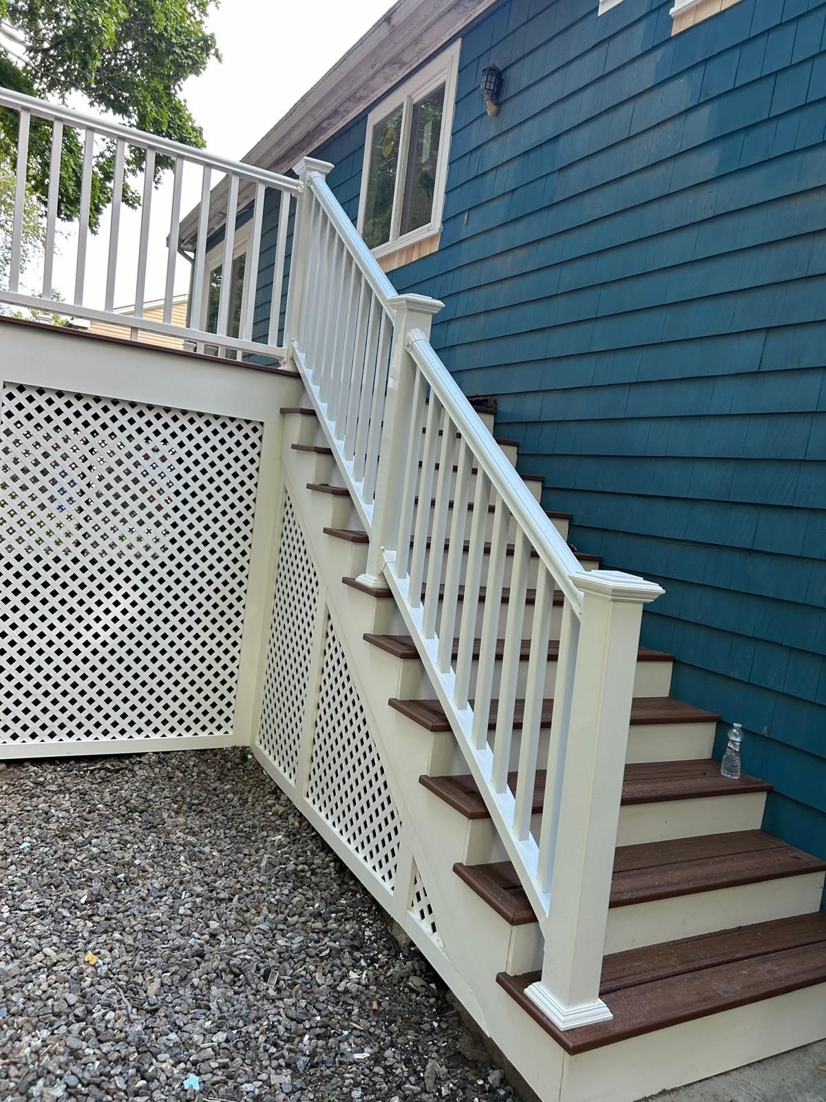 A blue house with white stairs and a white railing