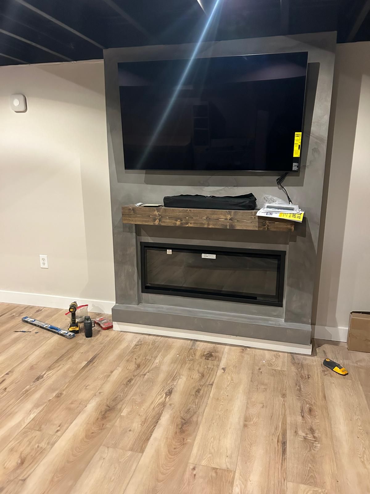 A living room with a fireplace and a flat screen tv on the wall.