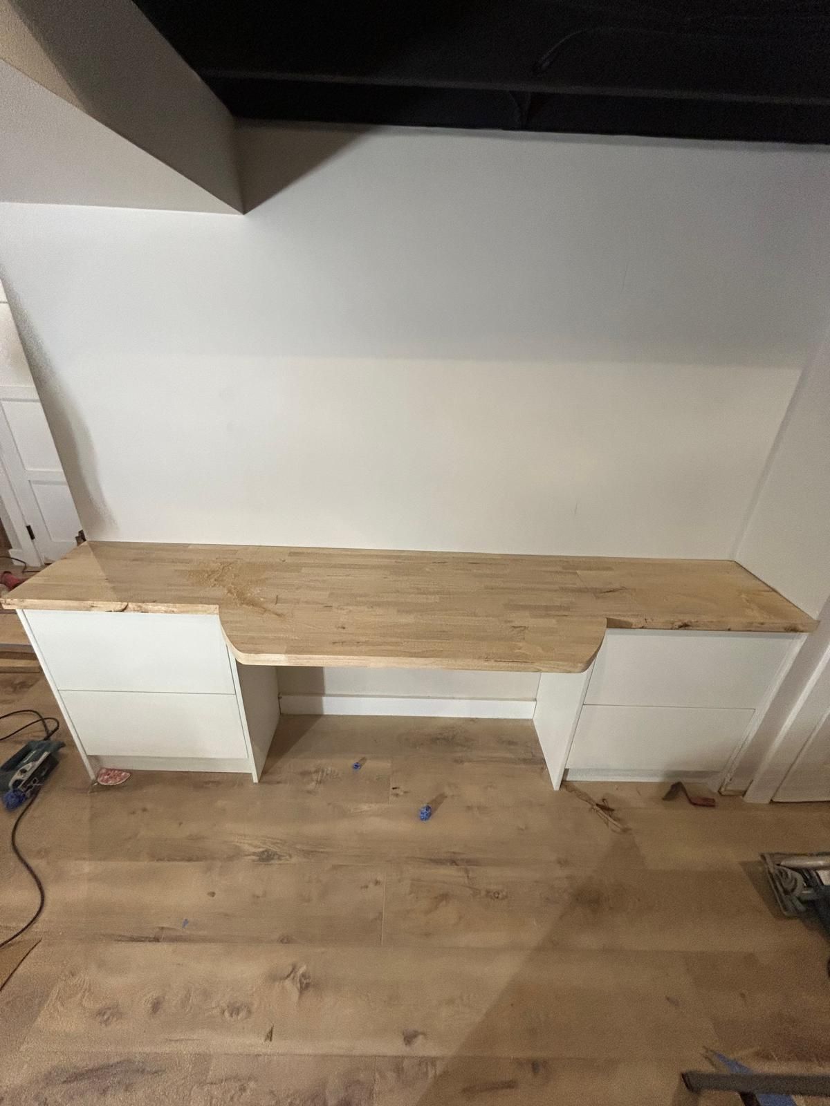 A wooden desk with drawers underneath it in a room.