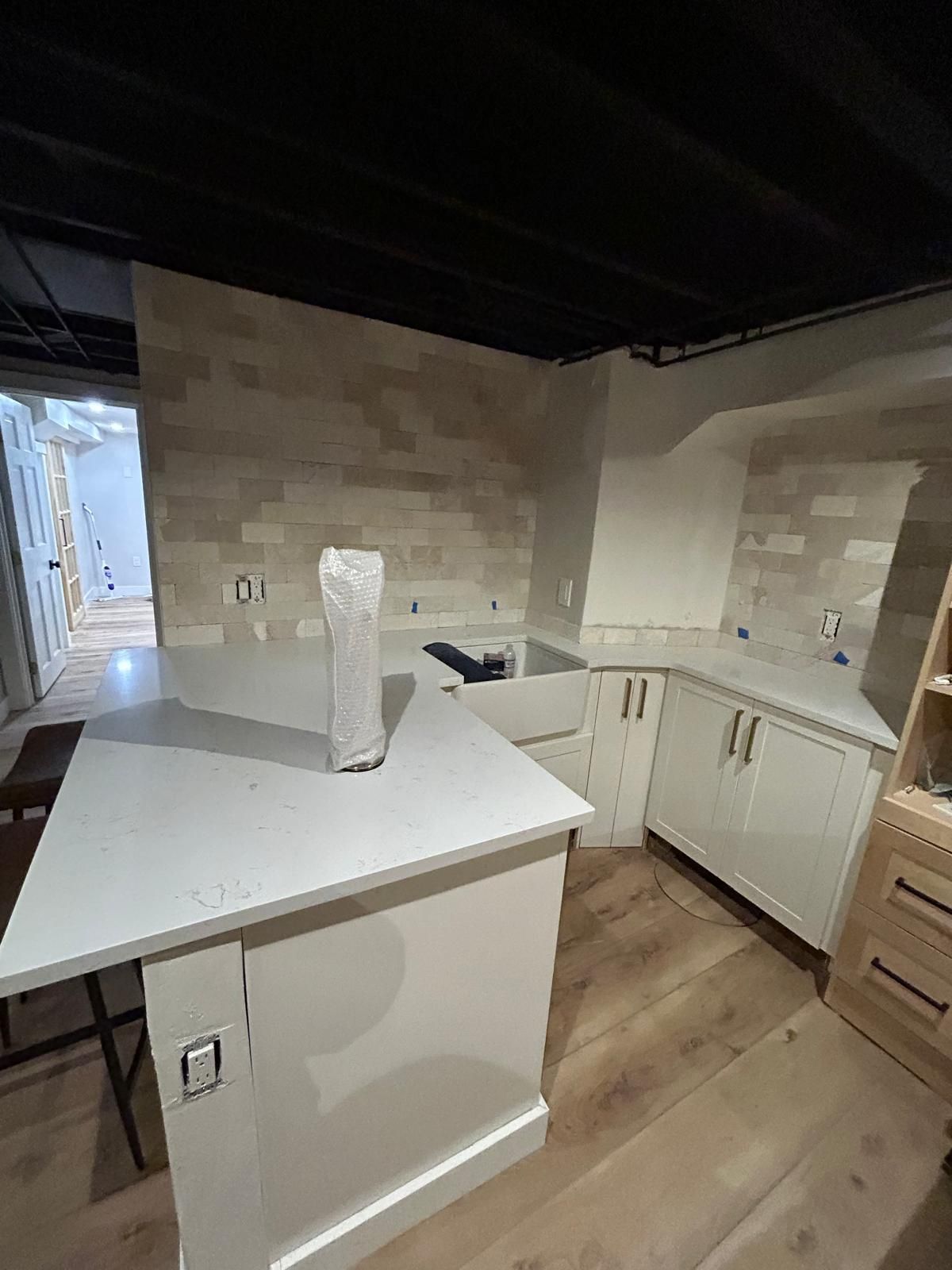 A kitchen with white cabinets and a large island in the middle of the room.