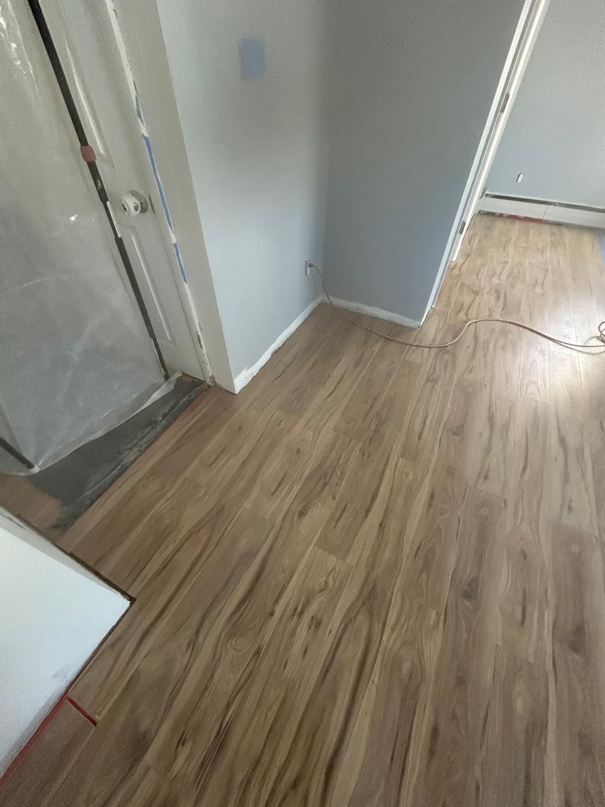 A room with a wooden floor and a door.