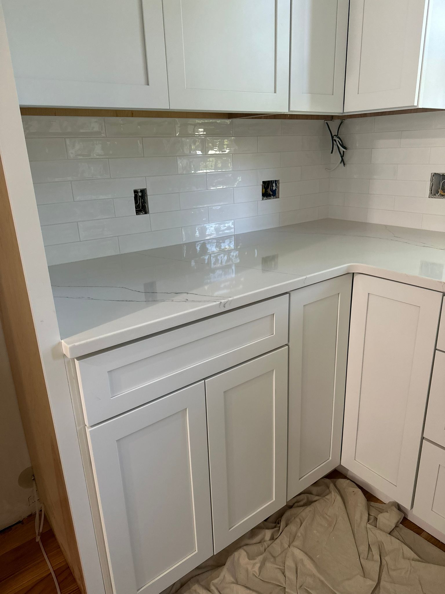 A kitchen with white cabinets and a white counter top.