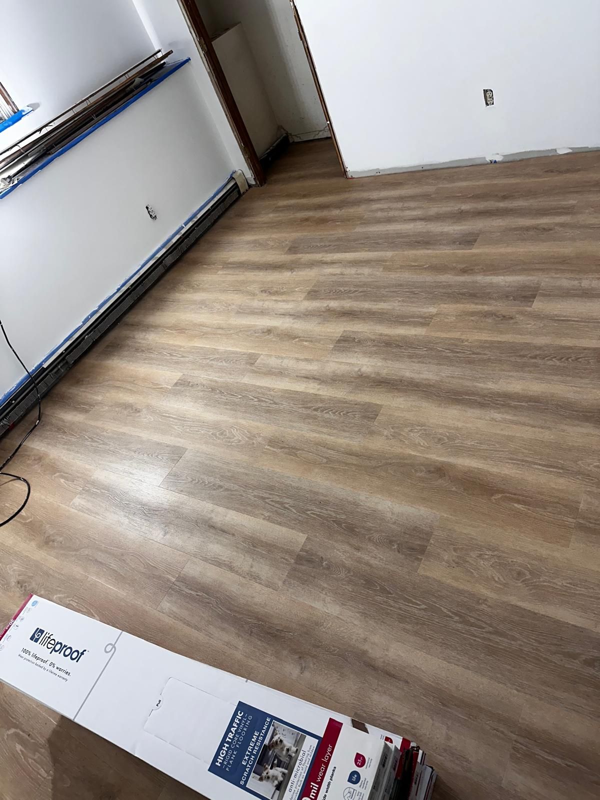 A room with a wooden floor and a box on the floor.