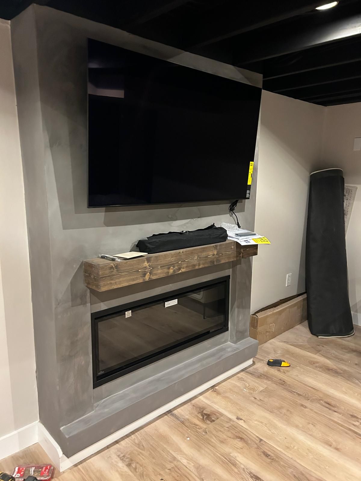 A living room with a fireplace and a flat screen tv on the wall.