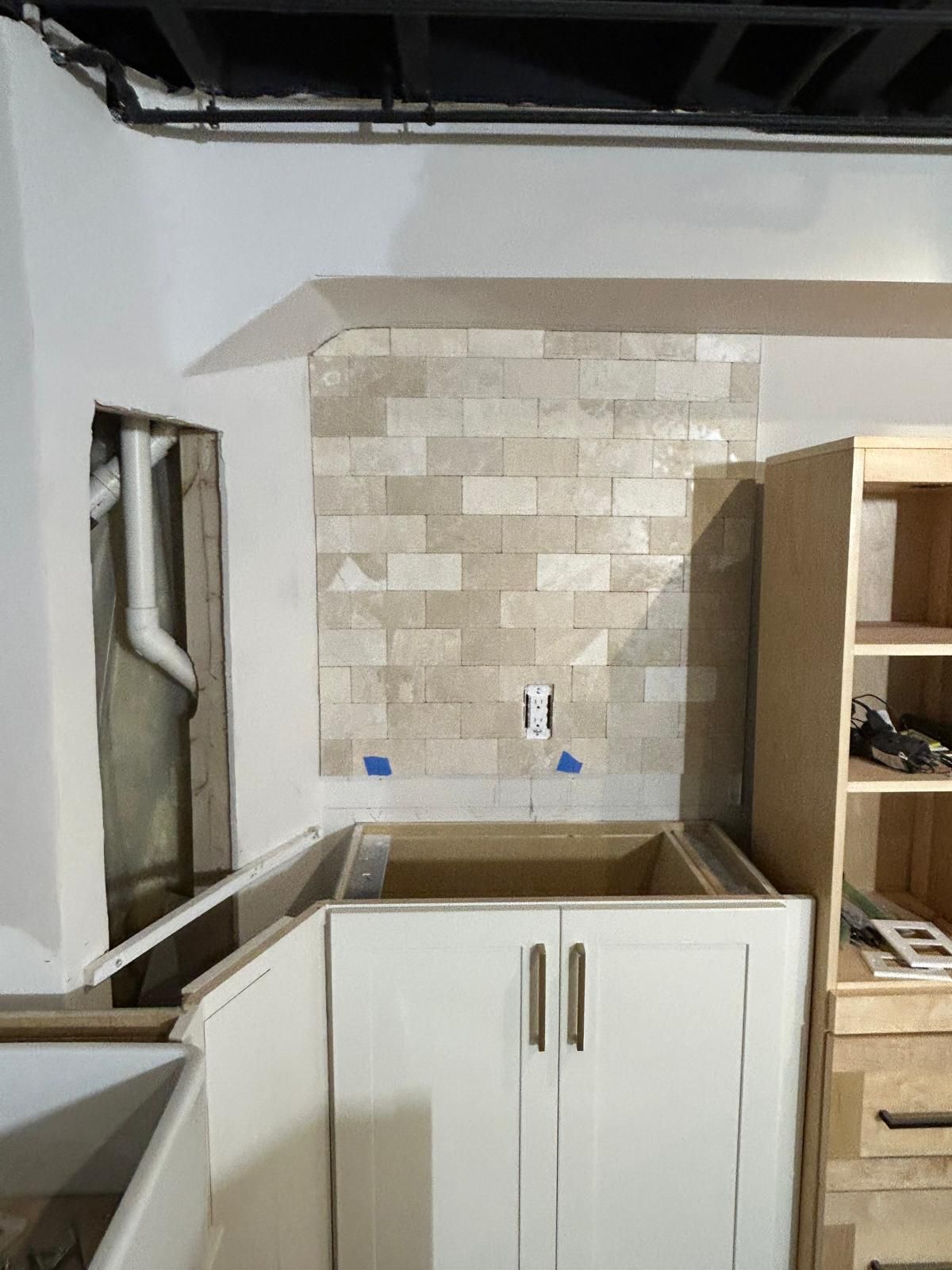 A kitchen with a sink and a brick wall