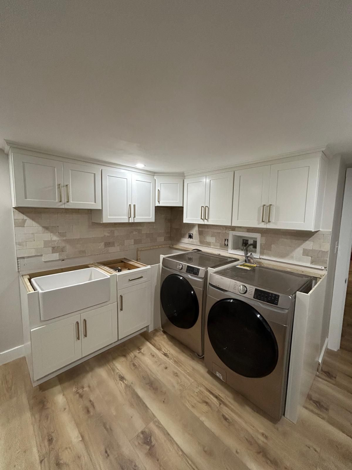 A laundry room with a washer and dryer and a sink.