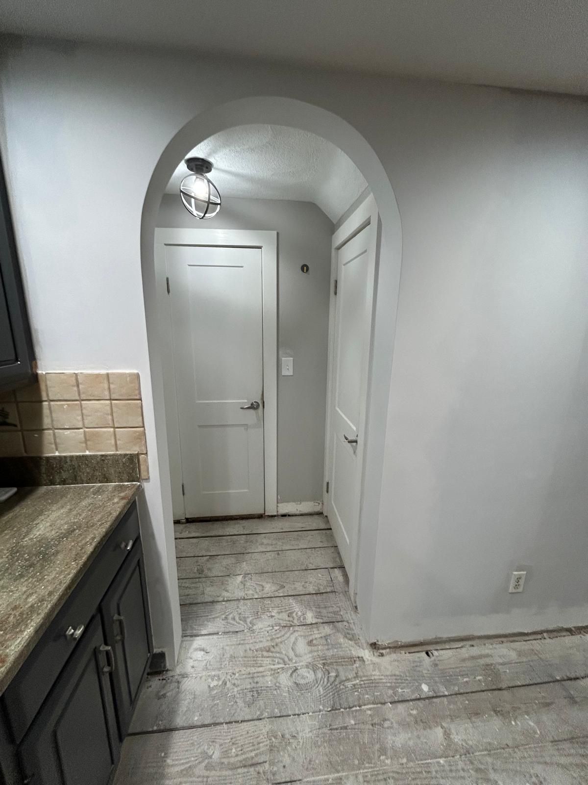 A kitchen with a doorway leading to a closet.