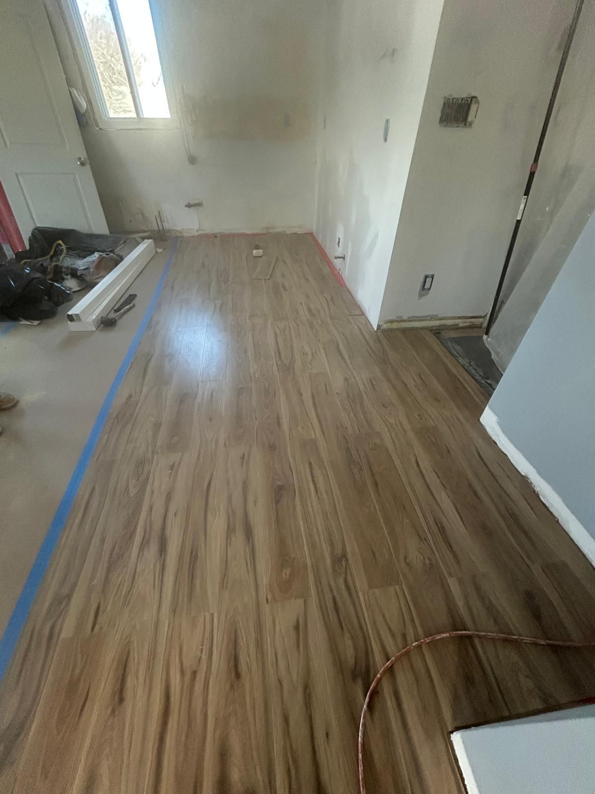 A room with a wooden floor and a window.