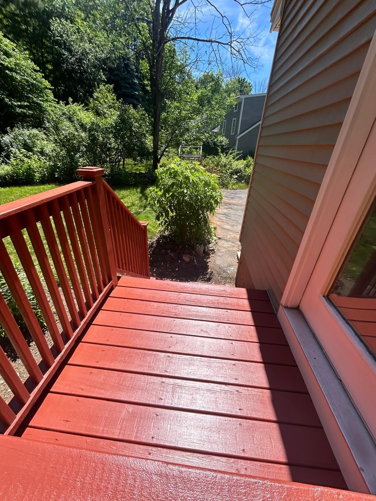 A red deck with stairs leading up to a house.