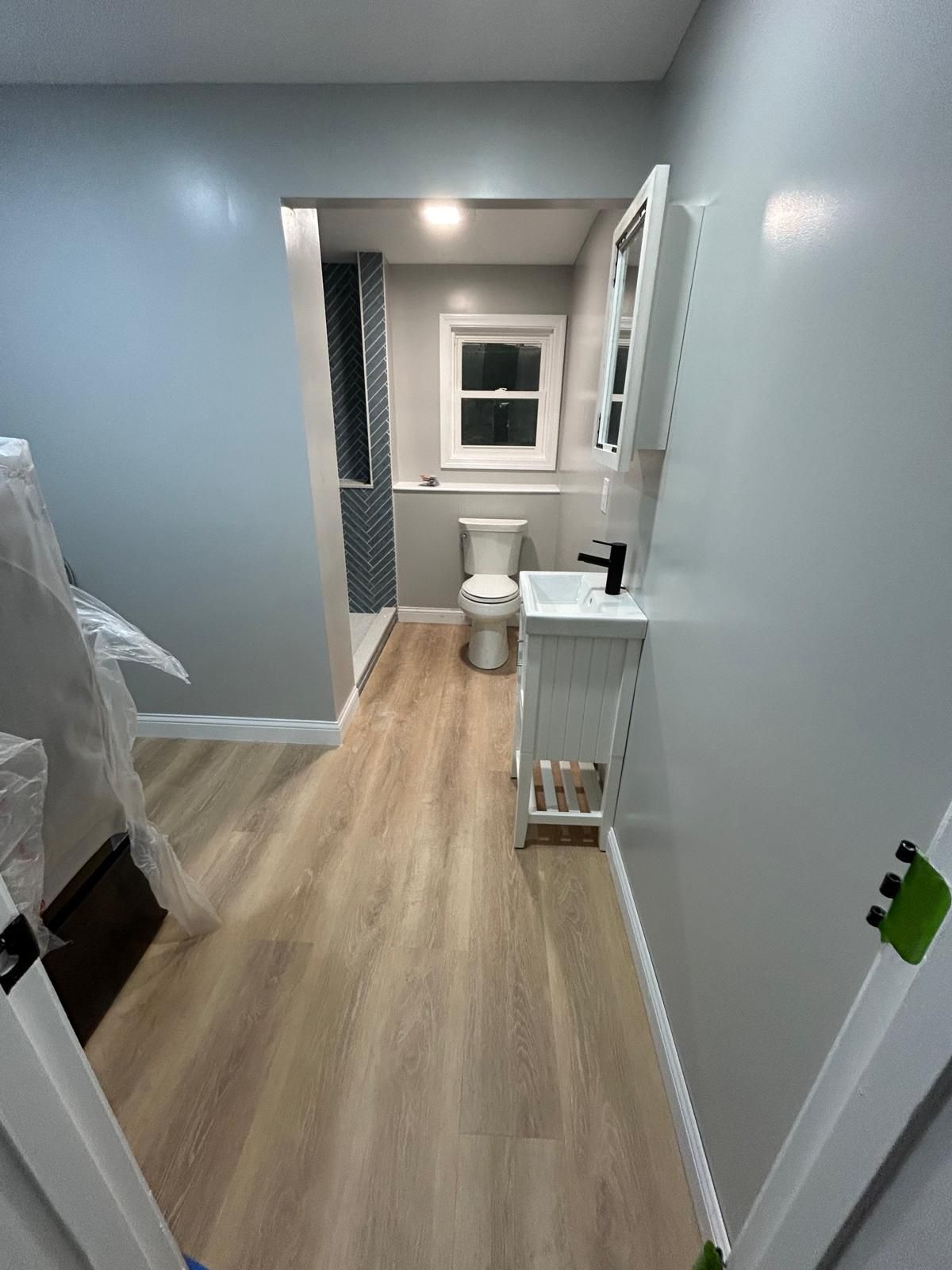 A bathroom with a toilet , sink and mirror.