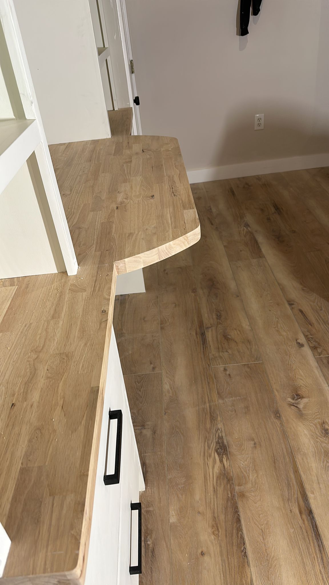 A close up of a wooden floor and stairs in a room.