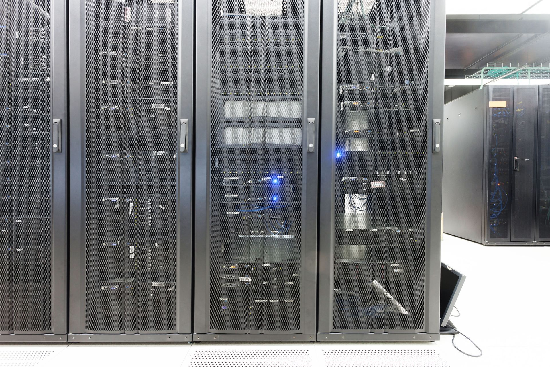 Row of black server racks with blue indicator lights in a data center room