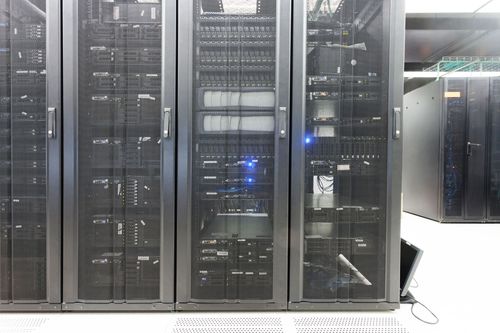 Row of black server racks with blue indicator lights in a data center room