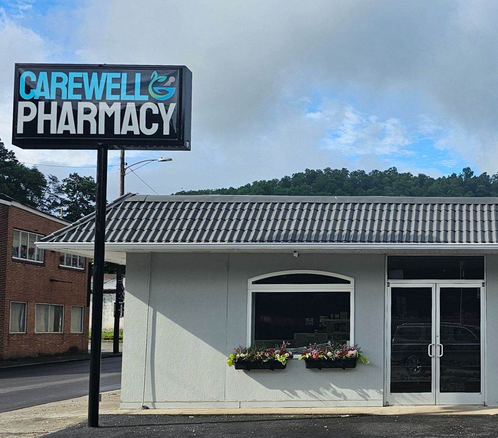 A white building with a sign that says Carewell Pharmacy