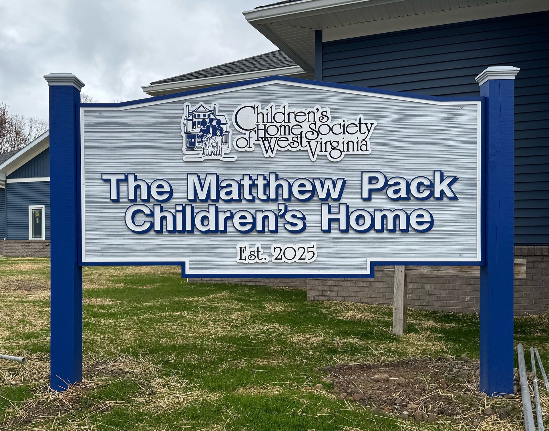 A blue sign for The Matthew Pack Children's Home