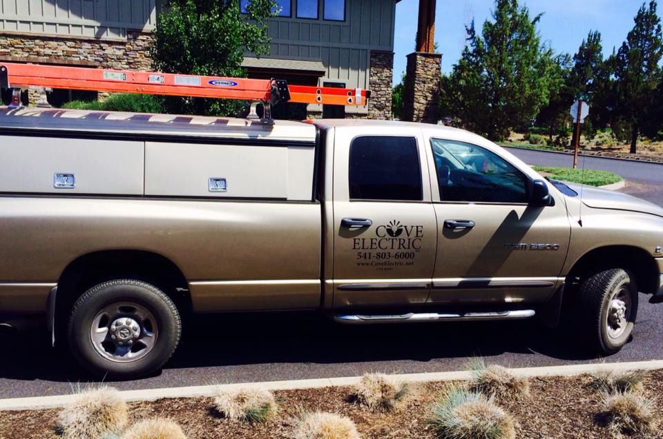 A copper electric truck is parked in front of a house