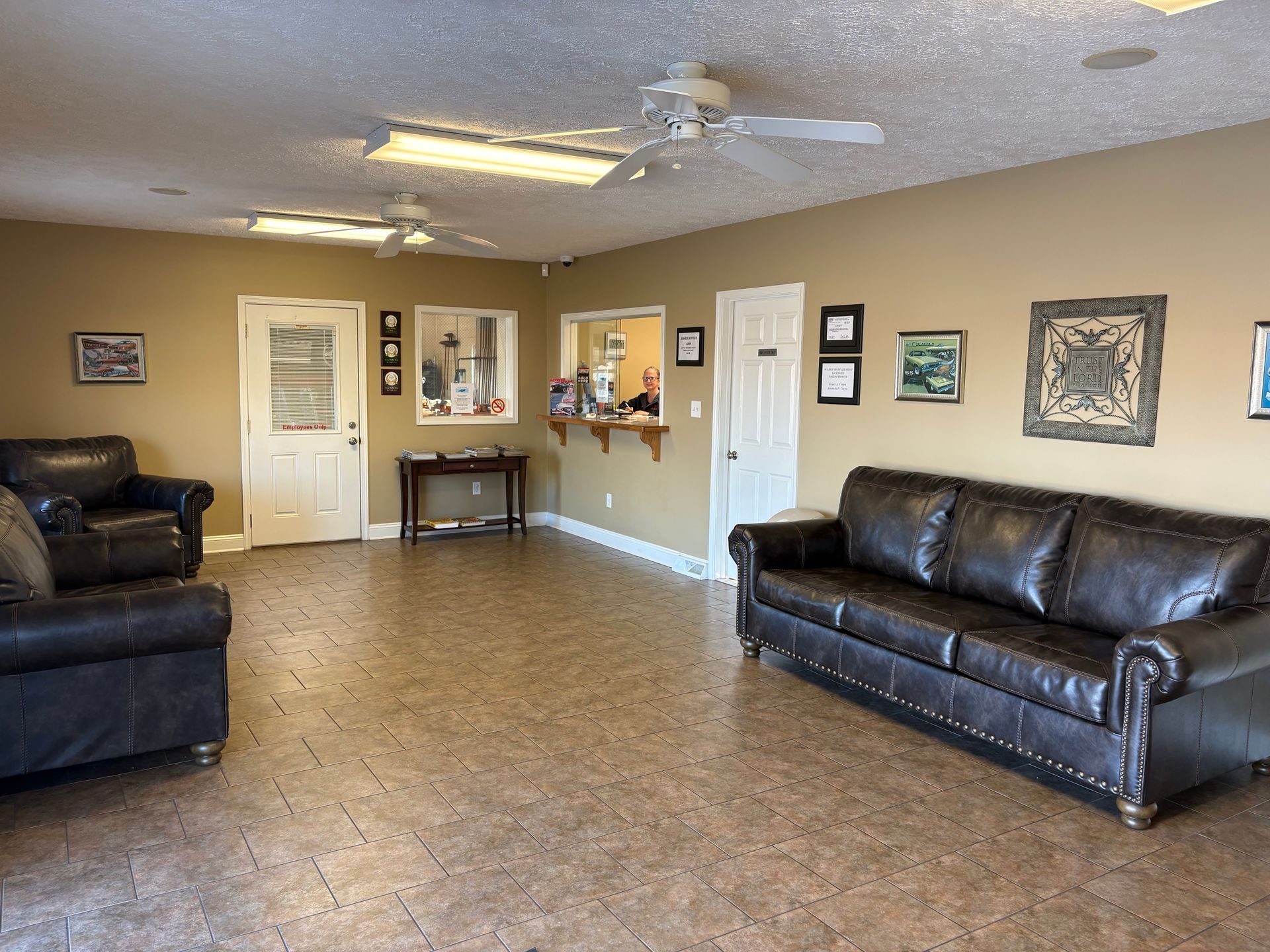Waiting room with leather furniture, tan walls, and a reception desk.