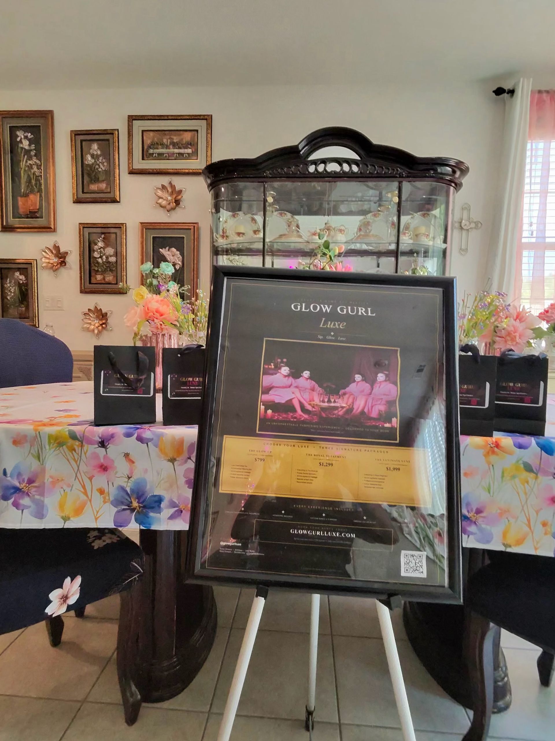 Memorial display on easel with framed photo and flowers in a dining room with a decorated table in the background