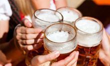 A group of people are toasting with beer mugs.