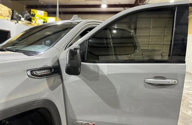 Gray SUV with driver’s door open in an indoor parking garage