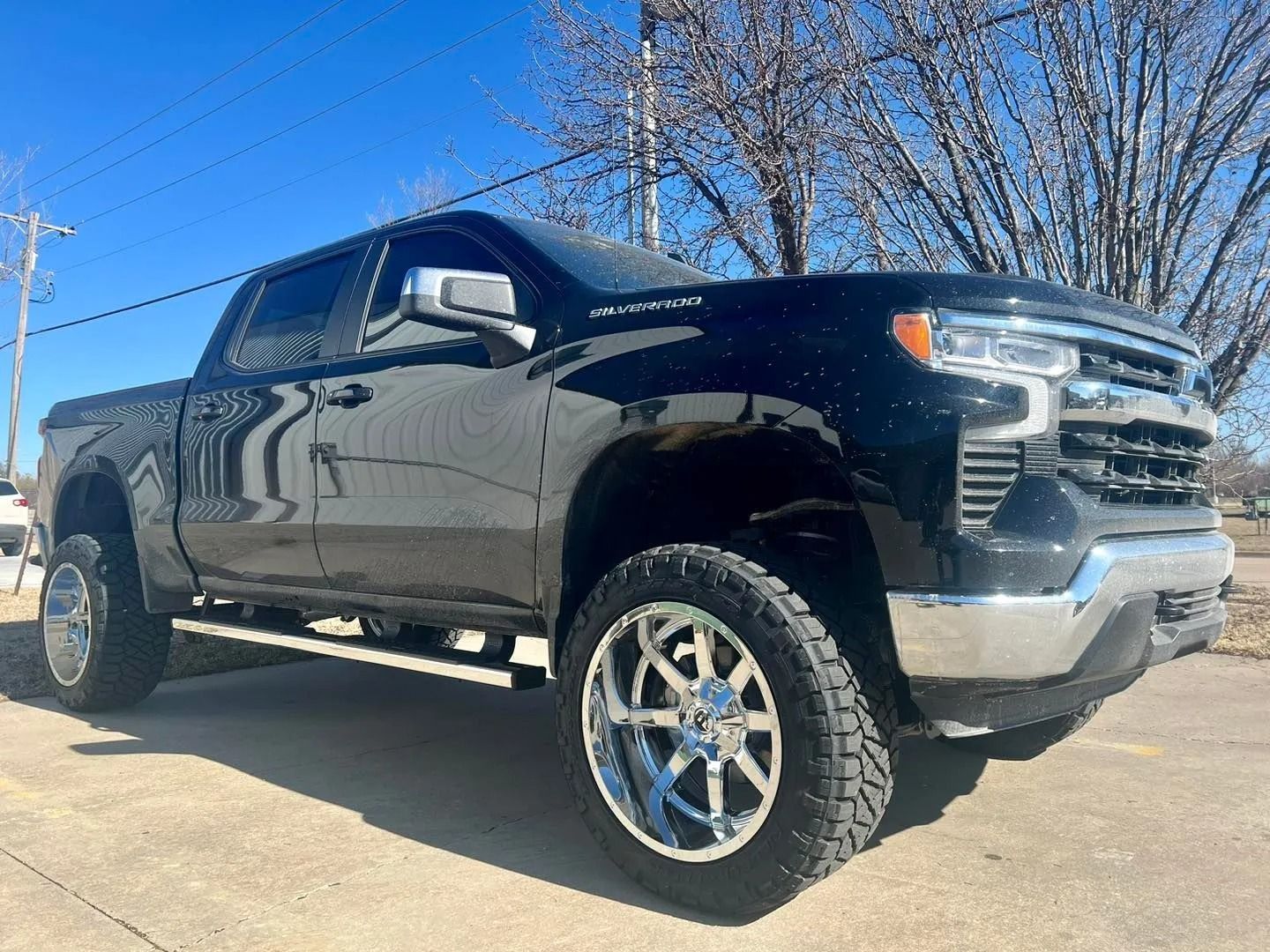 Black lifted pickup truck parked outdoors on a sunny day