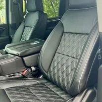 Black quilted leather car seats with diamond stitching and a center console in a vehicle interior