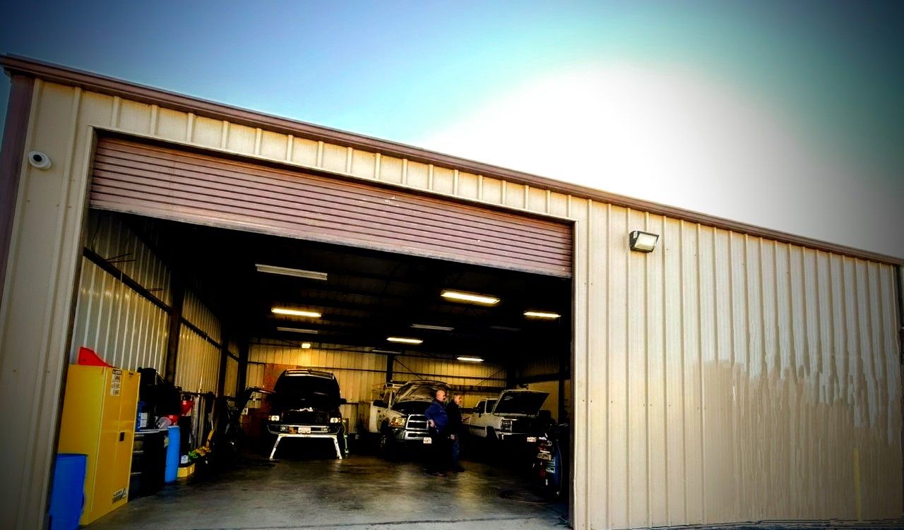 A garage with a lot of cars parked inside of it.