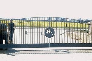 A couple of men are standing in front of a sliding gate.