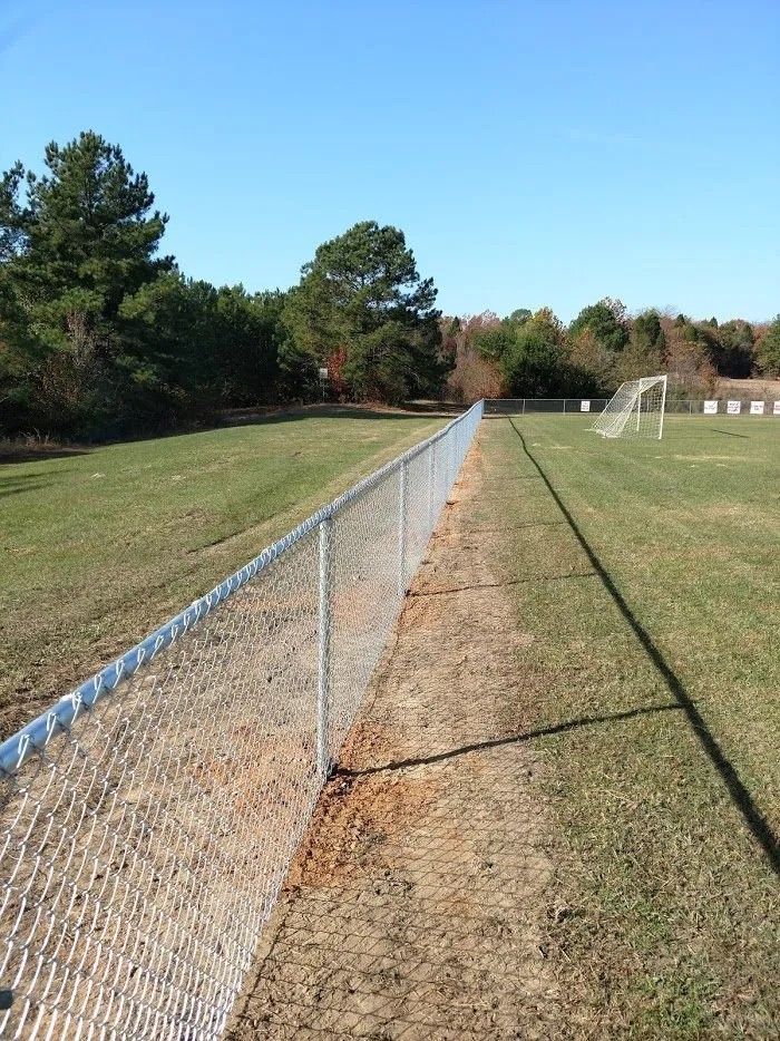 A chain link fence surrounds a soccer field