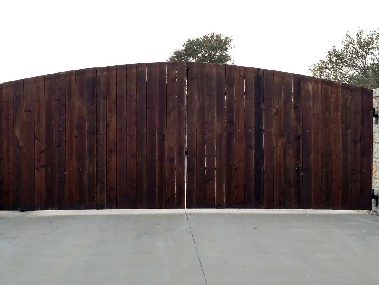 A wooden fence is sitting on top of a concrete driveway.