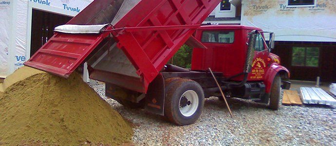 Red truck unloading sand
