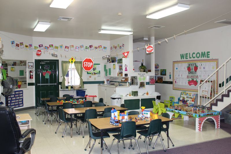 A classroom with tables and chairs and a welcome sign on the wall