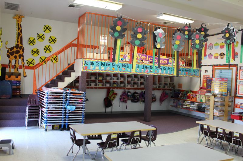 A classroom with tables and chairs and a sign that says welcome