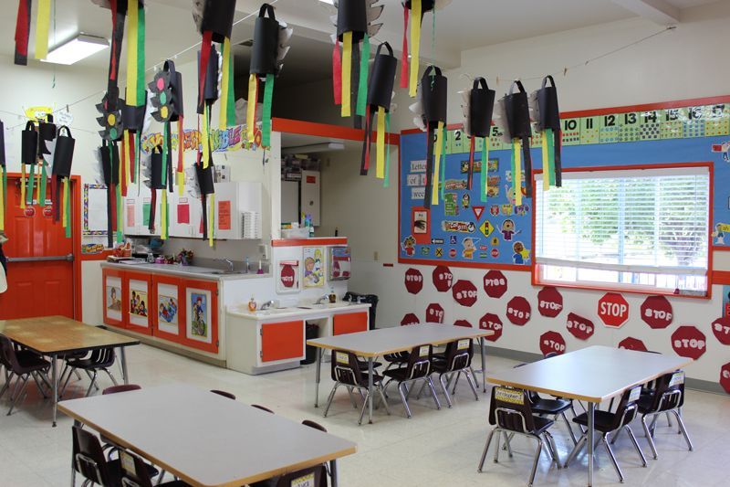 A classroom with tables and chairs decorated with traffic lights and stop signs