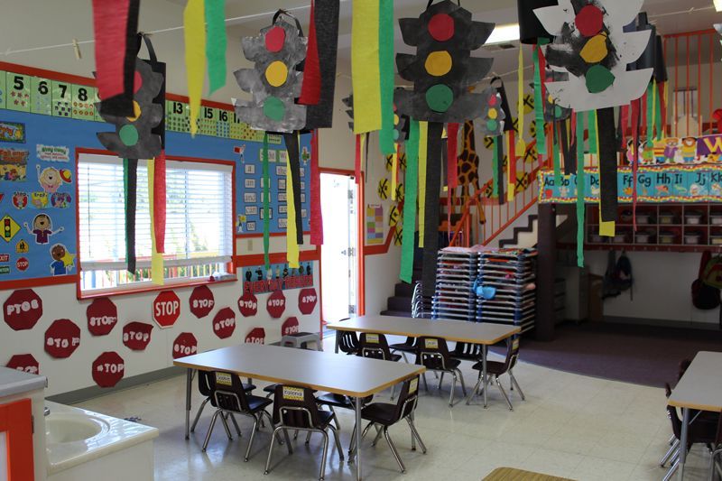 A classroom with tables and chairs and traffic lights hanging from the ceiling