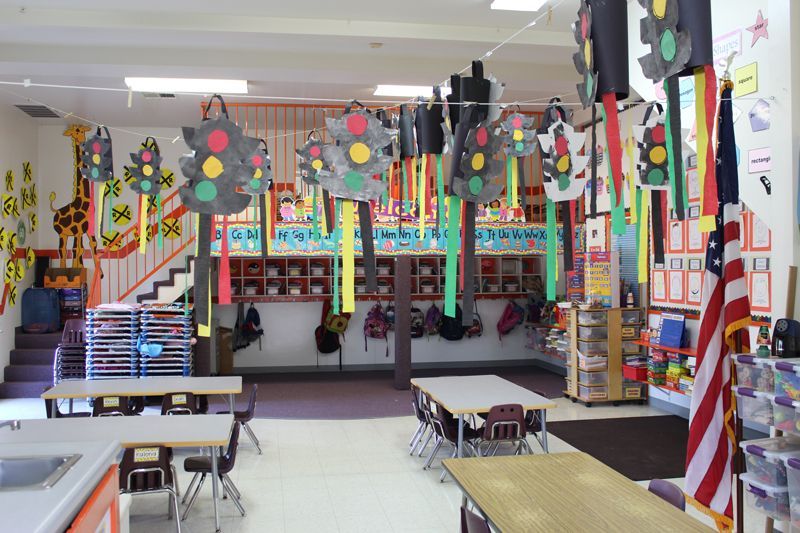 A classroom with tables and chairs and traffic lights hanging from the ceiling