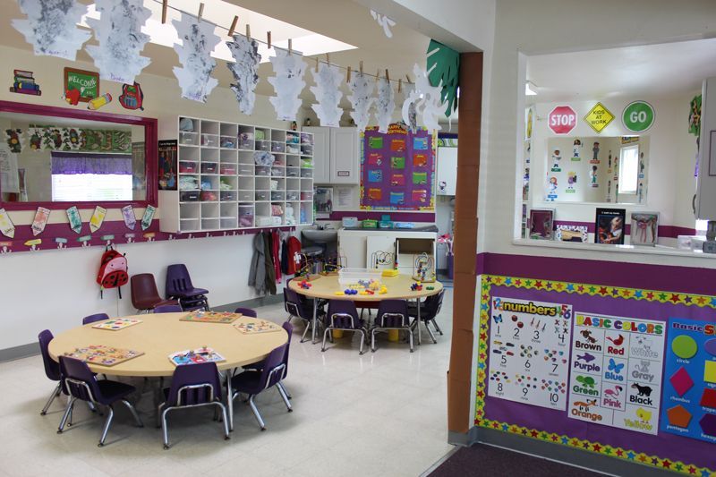 A classroom with a round table and purple chairs