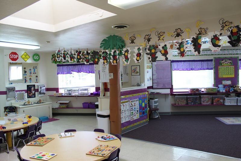 A classroom with tables and chairs and a stop sign on the wall