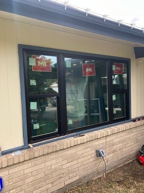 A large window is being installed on the side of a house.