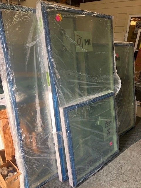 A stack of windows wrapped in plastic sitting on top of each other.