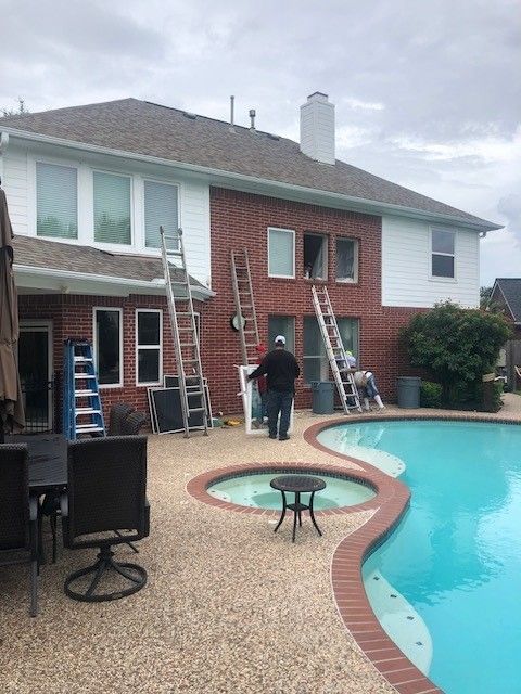 A man is standing in front of a house next to a pool