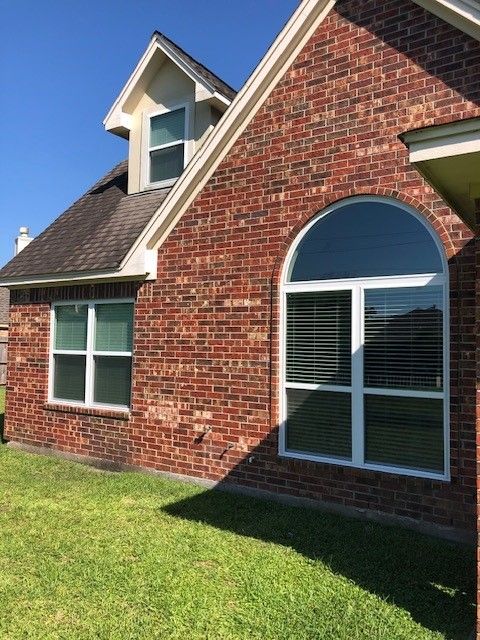 A brick house with arched windows and a roof